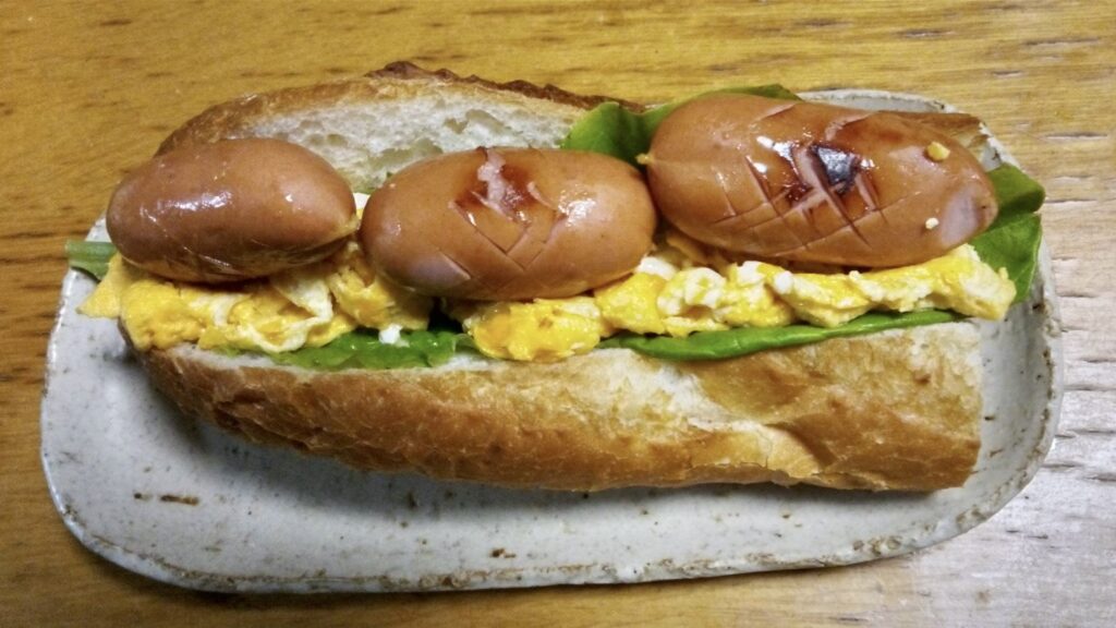 炒り卵とフランクフルトをフランスパンに挟んで